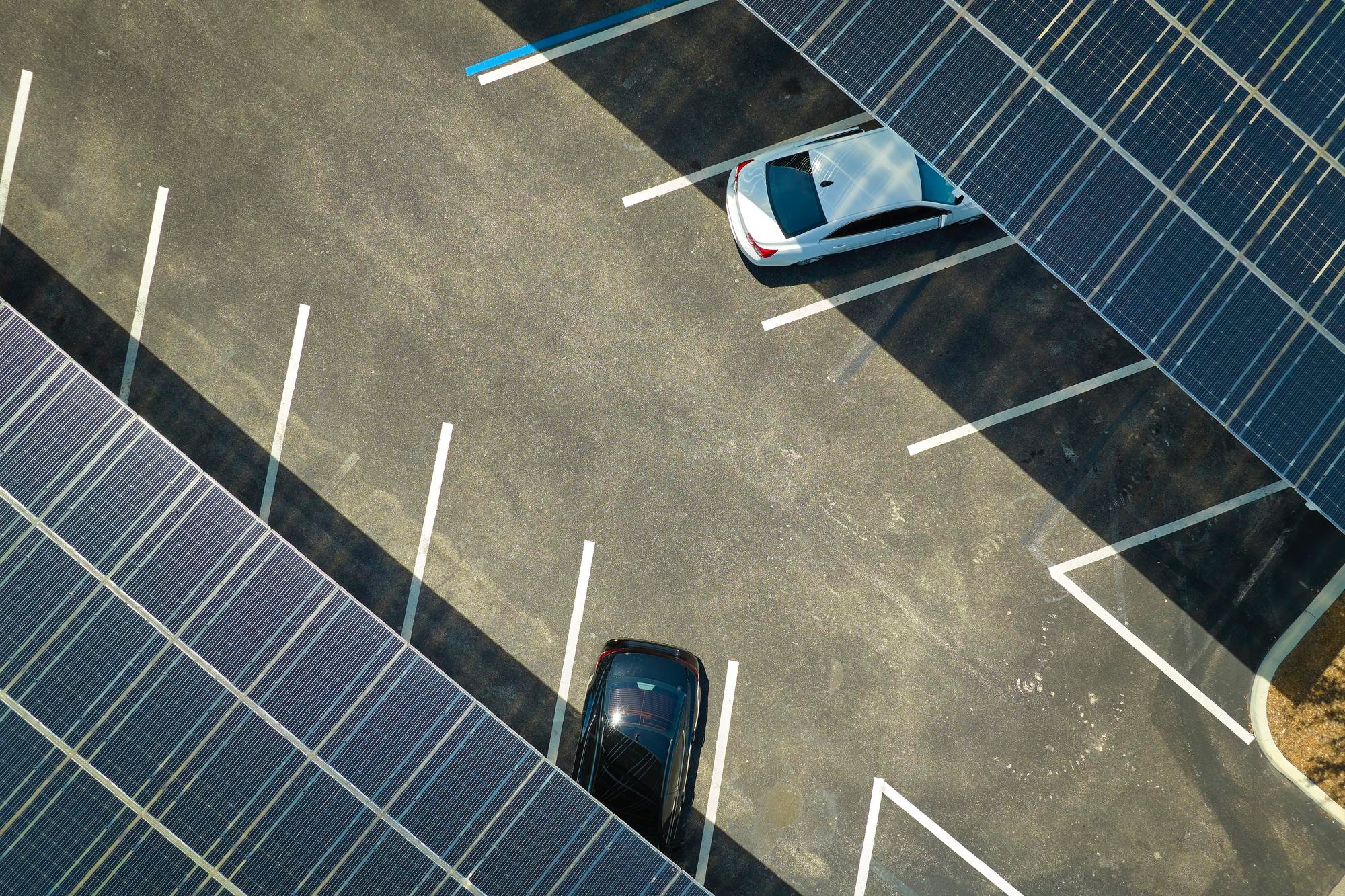 Solar panel structure installed over a parking lot, offering shade and clean energy generation, implemented by JM Green Technologies.